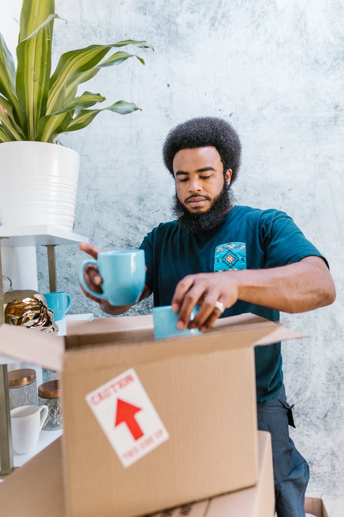 Man Packing Coffee Mugs in a Carboard Box